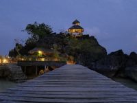 Beleuchteter Felsenpavillon und Steg des Sangat Island Dive Resort am Abend in der Coron Bay