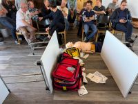 Notfallmedizin-Simulation mit Simulationspuppe, Rettungsausrüstung und Kursteilnehmern