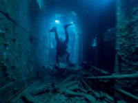 Taucher im Inneren eines historischen Schiffswracks in der Coron Bay bei Sangat Island